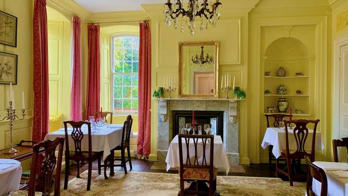 Ein Esszimmer mit Tischen und Stühlen und einem Kamin