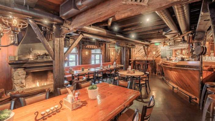 Ein Restaurant mit einem Tisch und Stühlen und einem Kamin