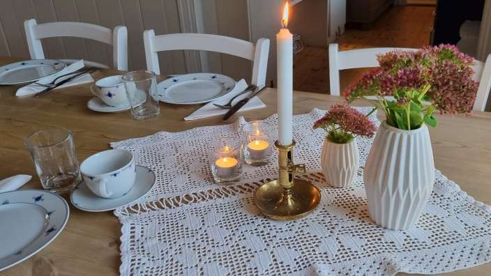 Ein Tisch mit einem Kerzenhalter und einer Vase mit Blumen darauf