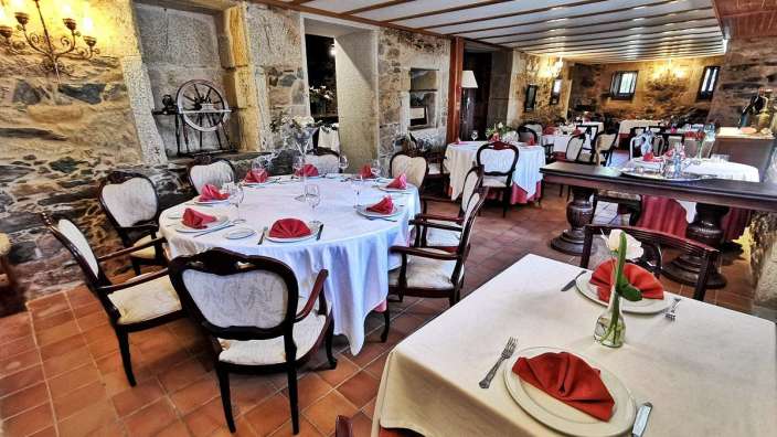 Ein Speisesaal mit Tischen und Stühlen mit weißen Tischdecken