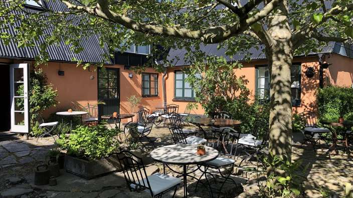 Eine Terrasse mit Tischen und Stühlen vor einem Haus