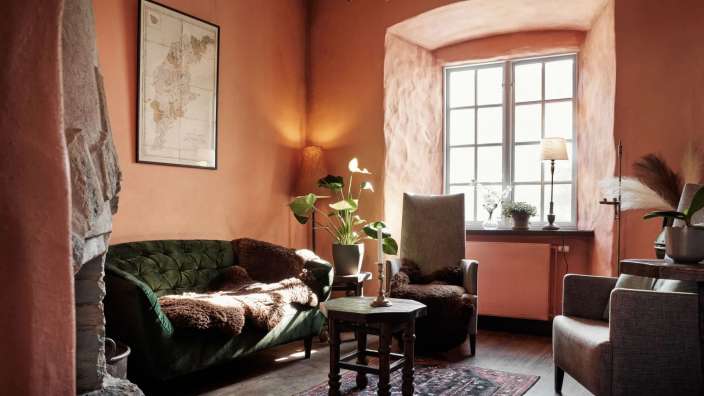 Ein Wohnzimmer mit einer grünen Couch und zwei Stühlen