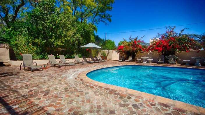 Ein großer Pool mit Liegestühlen und Sonnenschirmen um ihn