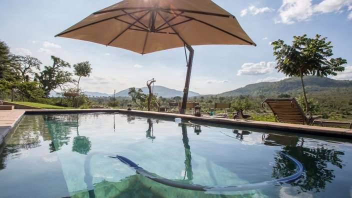 Ein Sonnenschirm hängt über einem Pool mit Blick auf die Berge