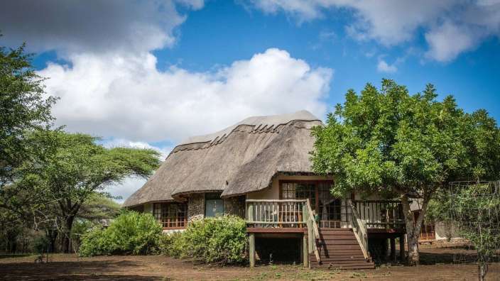 Ein Haus mit Strohdach und einer Holzterrasse