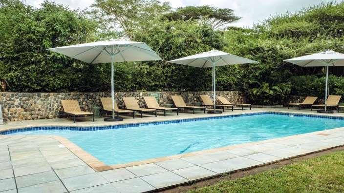 Liegestühle und Sonnenschirme umgeben einen großen Swimmingpool