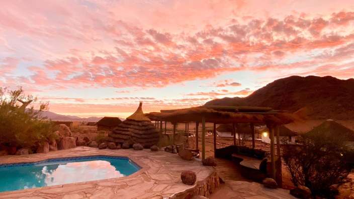 Ein Pool mit einem Sonnenuntergang im Hintergrund