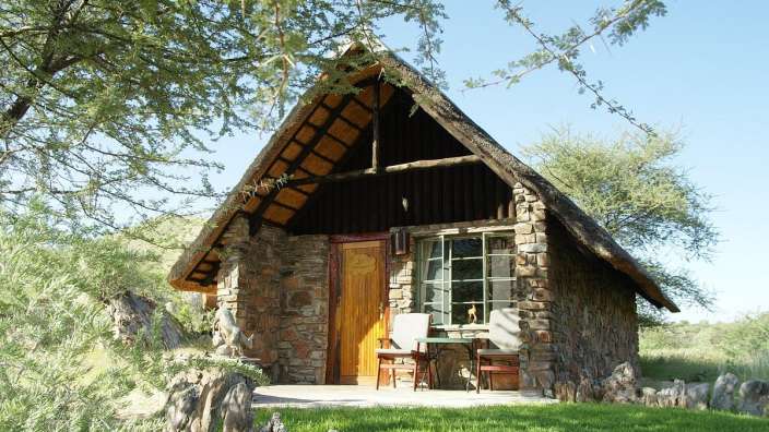 Ein kleines Steinhaus mit Strohdach und einer Holztür
