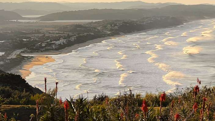 Ein Blick auf einen Strand mit Bergen im Hintergrund