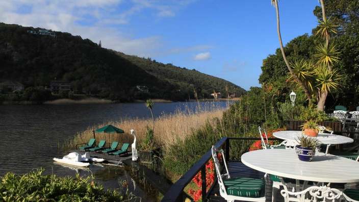 Ein Tisch und Stühle auf einem Deck mit Blick auf einen See