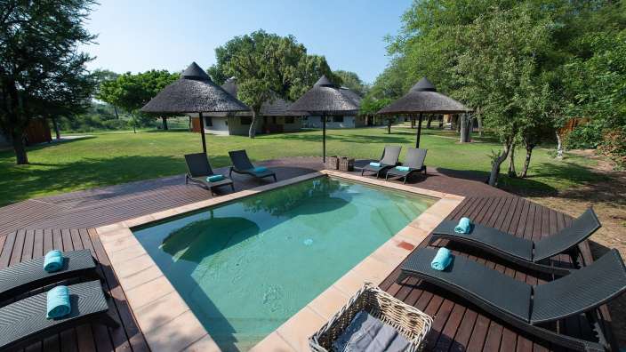 Ein großer Pool mit Liegestühlen und Sonnenschirmen um ihn