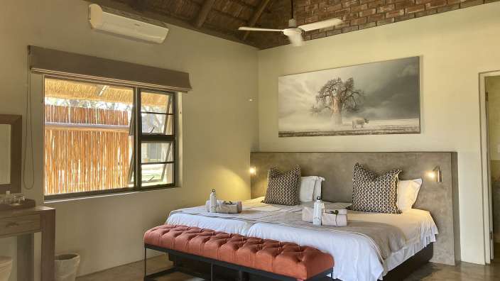 Ein Schlafzimmer mit zwei Betten und einem Gemälde an der Decke