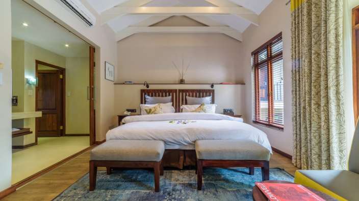 Ein Schlafzimmer mit einem Bett und zwei Hockern