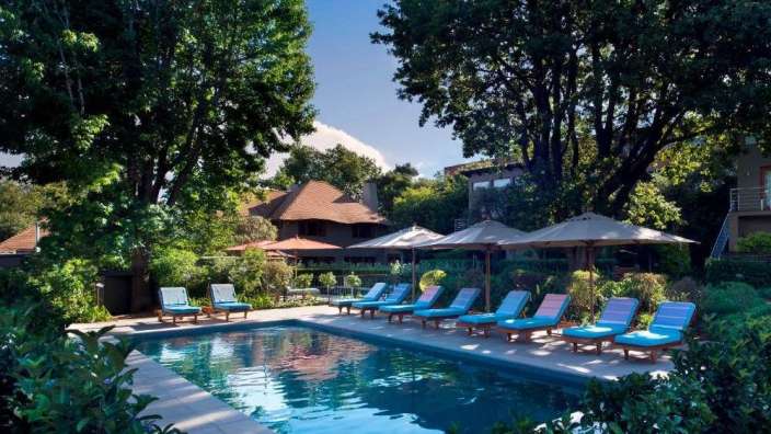 Liegestühle und Sonnenschirme umgeben einen großen Swimmingpool