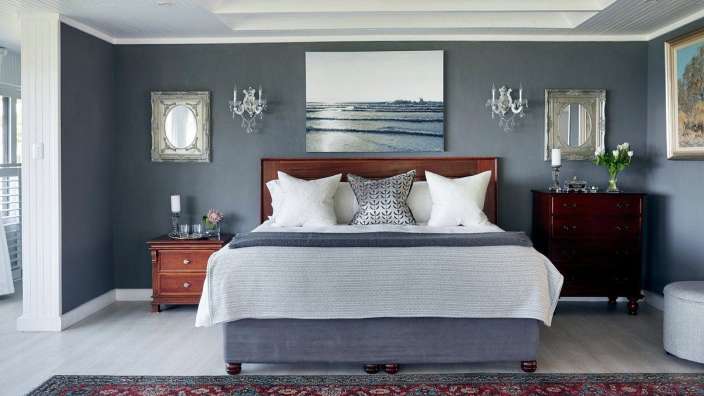 Ein Schlafzimmer mit grauen Wänden und einem Bett