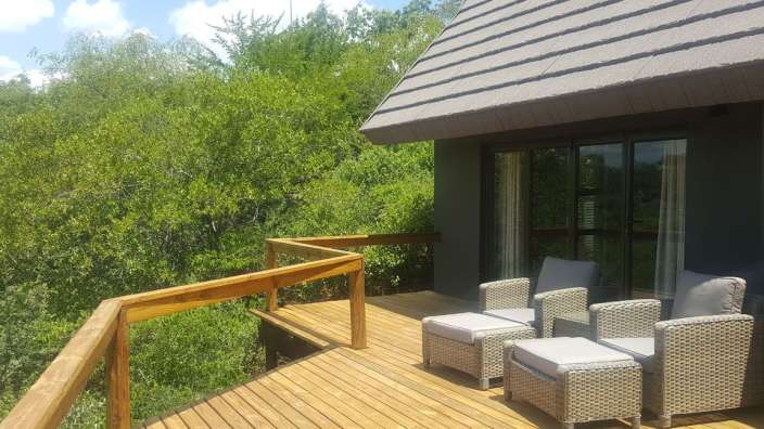 Ein Holzdeck mit Stühlen und einem Tisch darauf