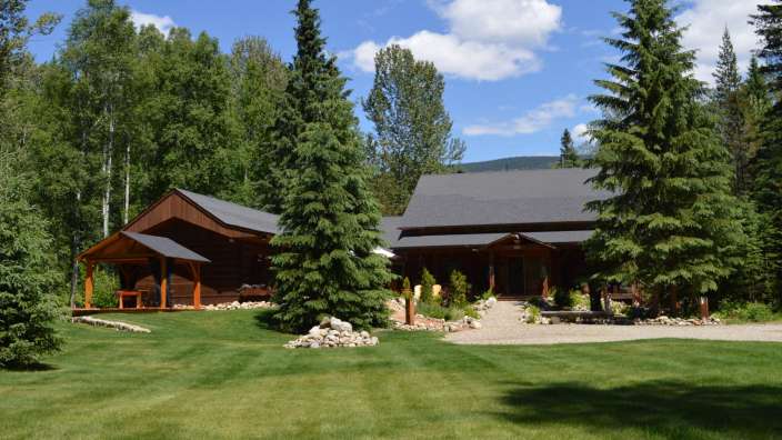 Ein Haus mit einem schwarzen Dach steht inmitten eines Waldes