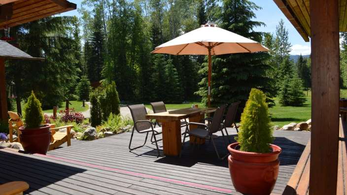 Ein Deck mit einem Tisch und Stühlen und einem Regenschirm