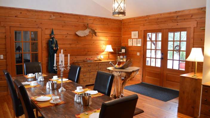 Ein Esszimmer mit einem langen Holztisch und Stühlen