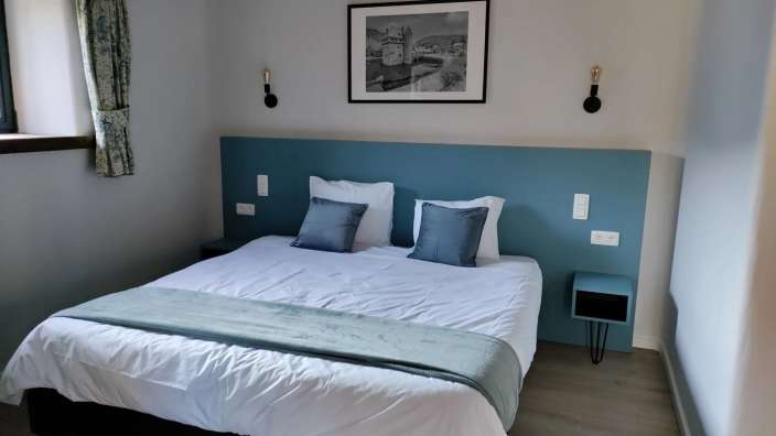 Ein Schlafzimmer mit einem Bett und einem Gemälde an der Wand