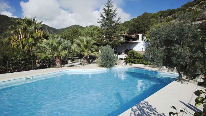 Ein großer Swimmingpool mit einem weißen Haus im Hintergrund