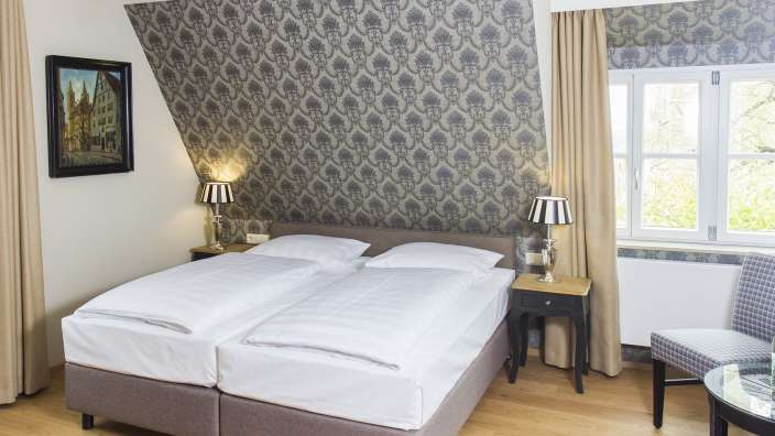 Ein Hotelzimmer mit zwei Betten und zwei Lampen