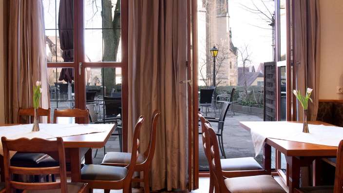 Tische und Stühle in einem Restaurant mit Blick auf eine Kirche