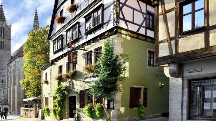 Ein grünes Gebäude mit einem Schild an der Seite, das sagt " hotel "