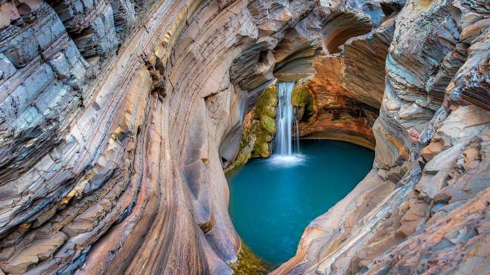 Ein Wasserfall in einer Schlucht mit blauem Wasser