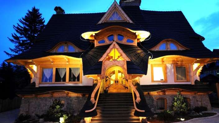 Ein Haus mit einem schwarzen Dach und einem Holzeingang