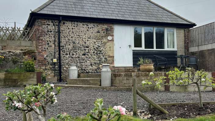 Ein kleines Backsteinhaus mit einer weißen Tür