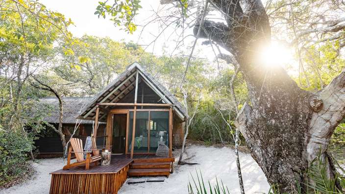 Ein kleines Holzhaus auf einem sandigen Strand