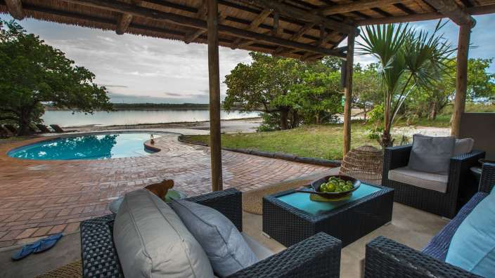 Eine Terrasse mit Möbeln und einem Swimmingpool im Hintergrund