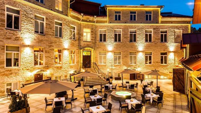 Ein Gebäude mit vielen Tischen und Stühlen davor