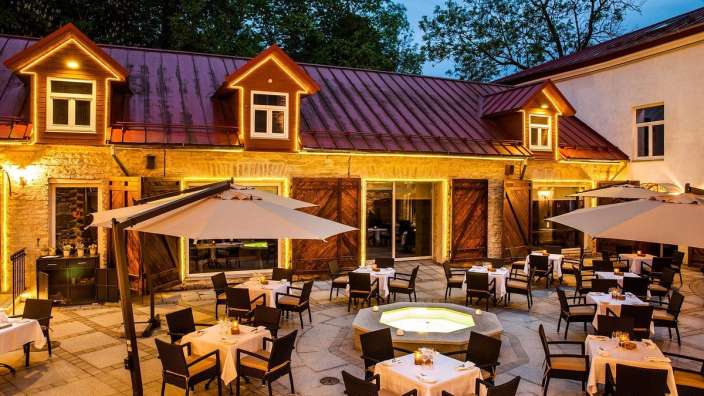 Eine Terrasse mit Tisch und Stühlen und Sonnenschirmen