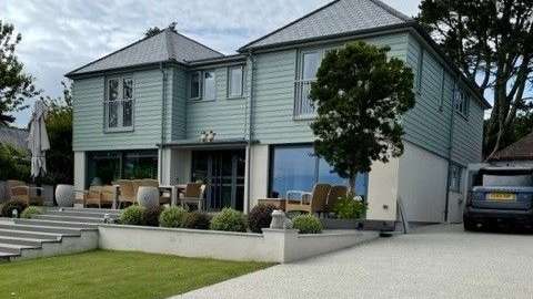 Ein großes Haus mit einem Auto, das vorne geparkt ist .