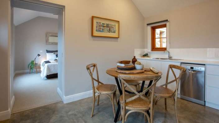 Eine Küche mit einem Tisch und Stühlen und einem Bild an der Wand