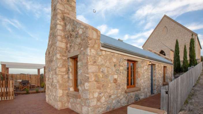 Ein kleines Steinhaus neben einer Kirche