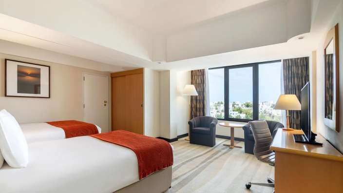 Ein Hotelzimmer mit zwei Betten und einem Schreibtisch