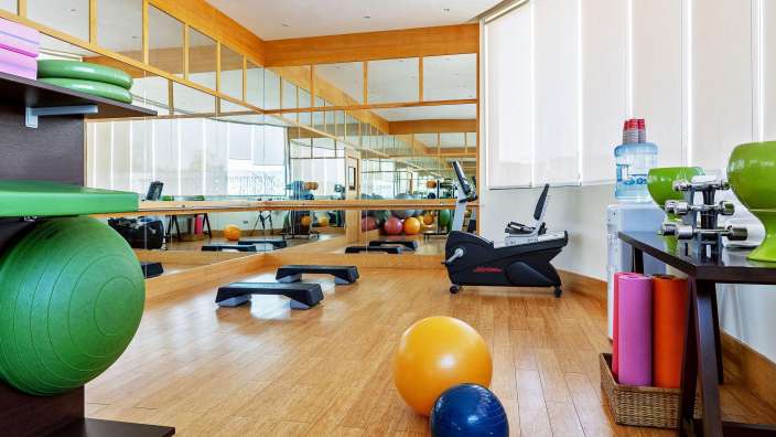 Ein Fitnessstudio mit vielen Bällen und einem Laufrad