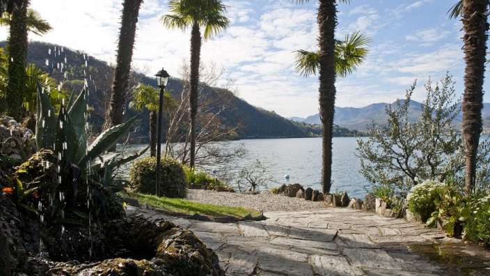 Ein Wasserfall in einem Garten mit Blick auf einen See