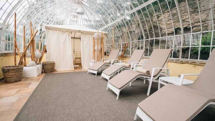 Eine Reihe von Liegestühlen in einem Gewächshaus