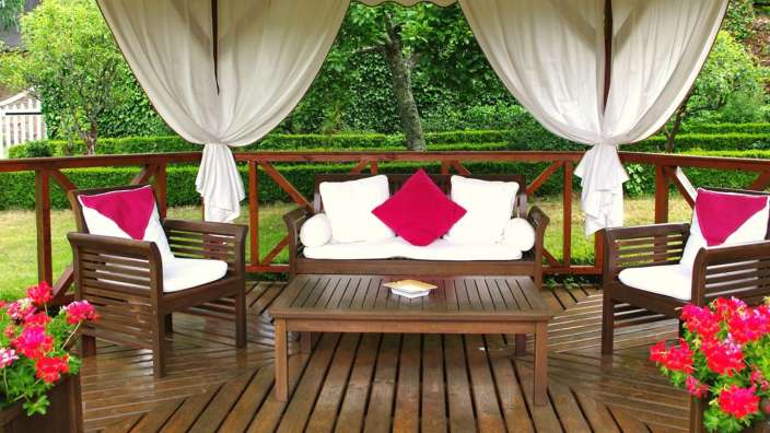 Ein hölzerner Pavillon mit einem Couchtisch und Stühlen