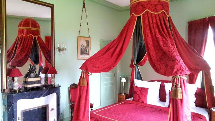 Ein Schlafzimmer mit einem Himmelbett und einem Kamin