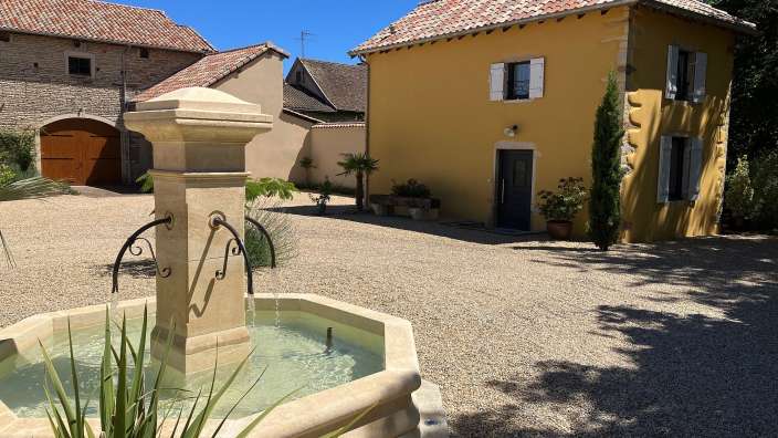 Ein Brunnen steht vor einem gelben Gebäude