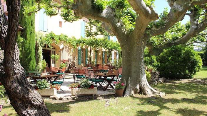 Eine Terrasse mit Tischen und Stühlen vor einem Gebäude