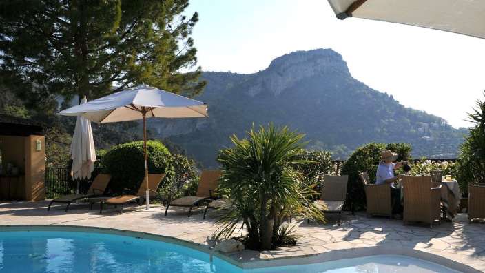 Ein Mann sitzt an einem Tisch in der Nähe eines Pools