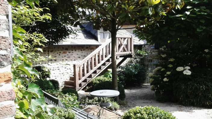 Ein Tisch und Stühle stehen in einem Garten neben einer Treppe