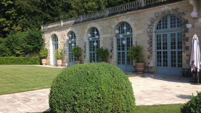 Eine große grüne Kugel steht vor einem Gebäude mit blauen Fenstern