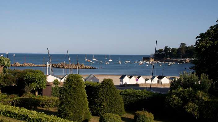 Eine Gruppe von Strandhütten steht am Ufer des Ozeans